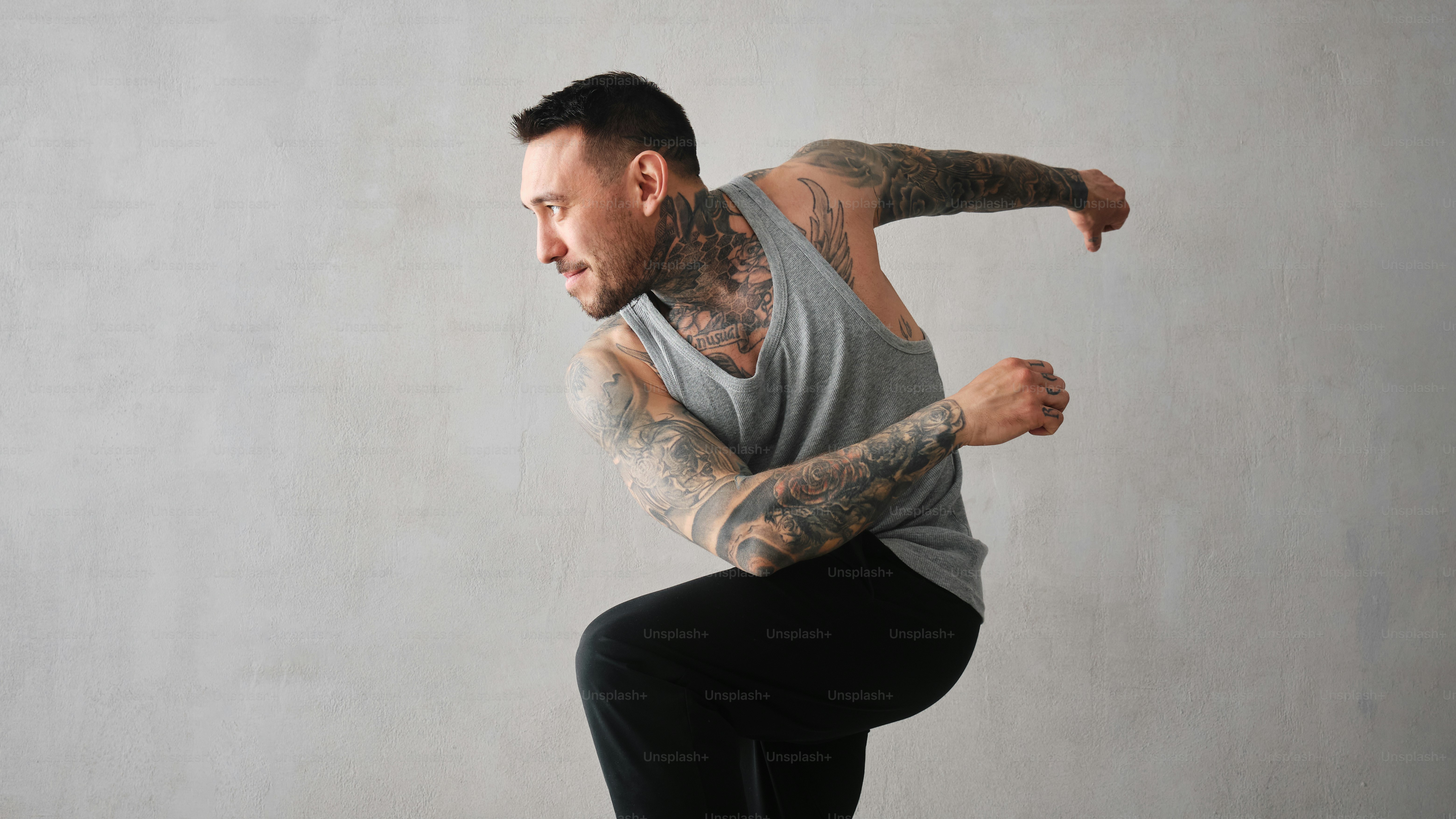a man with a tattooed arm doing a trick on a skateboard