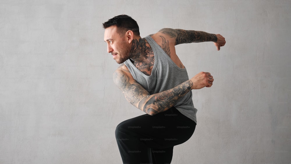 a man with a tattooed arm doing a trick on a skateboard
