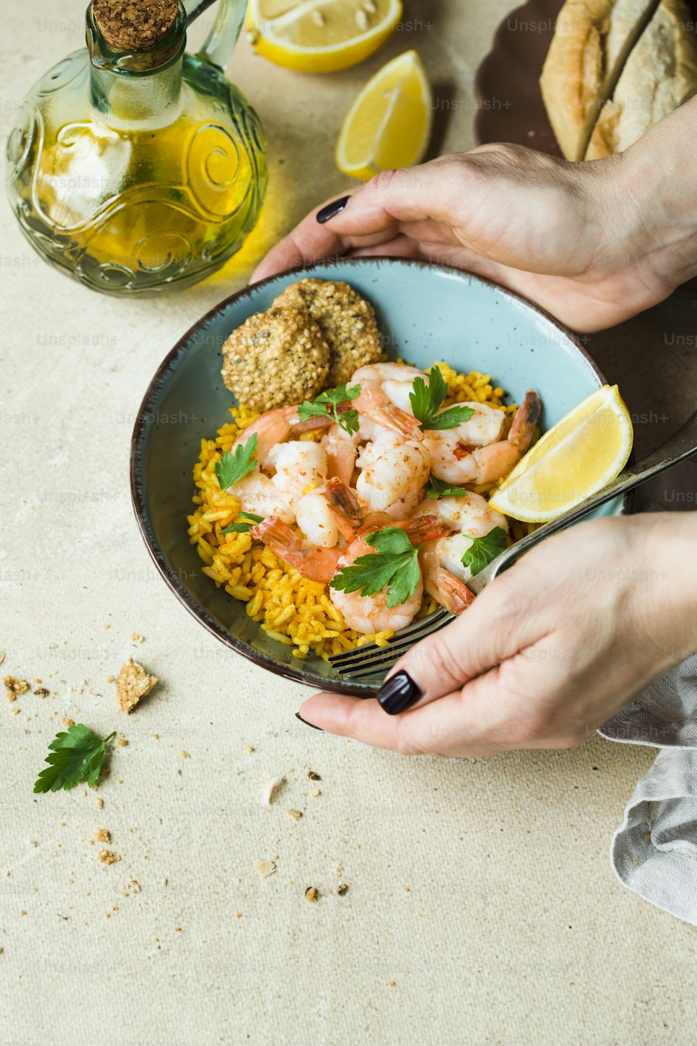 a person holding a bowl of food with shrimp and rice