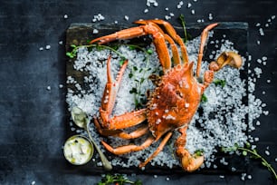 un crabe cuit sur une assiette noire avec une cuillère