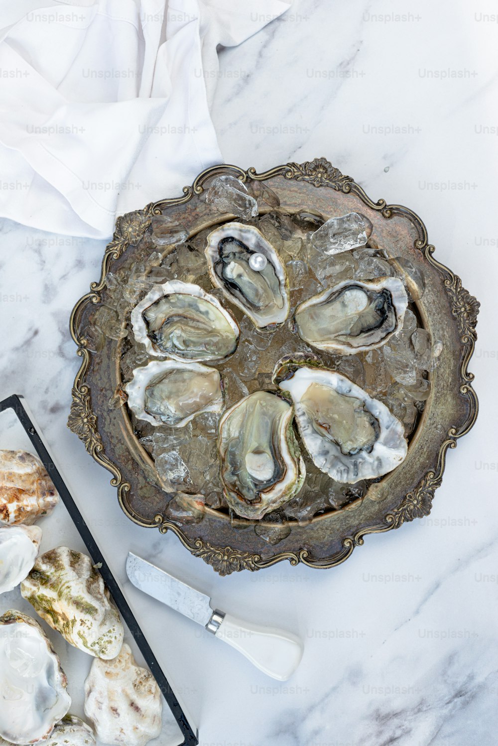 a platter of oysters on a marble table