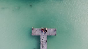 a group of people standing on a pier over the ocean