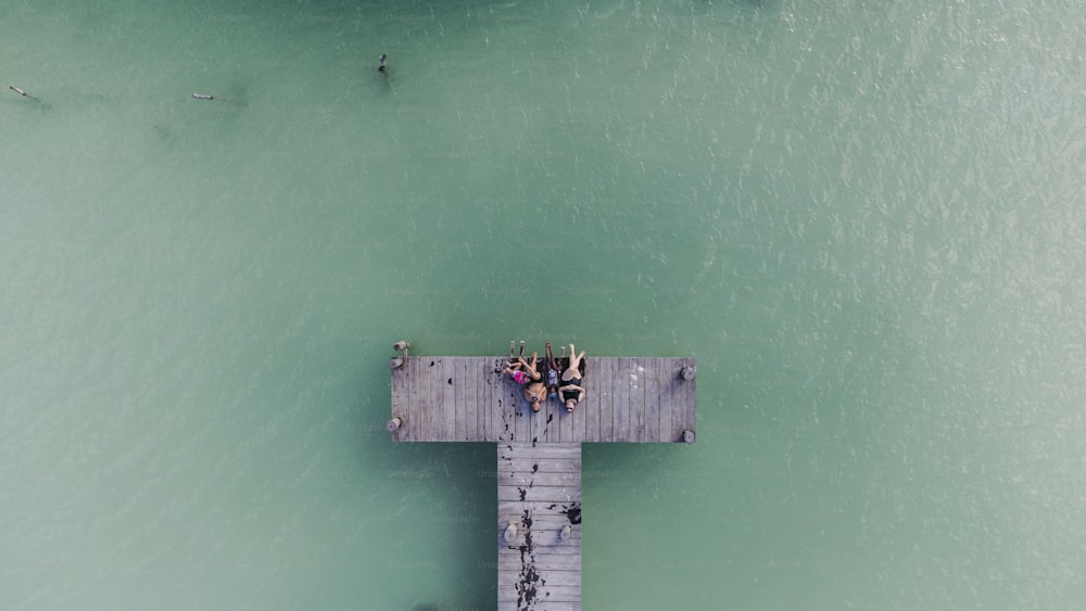 un gruppo di persone in piedi su un molo sopra l'oceano