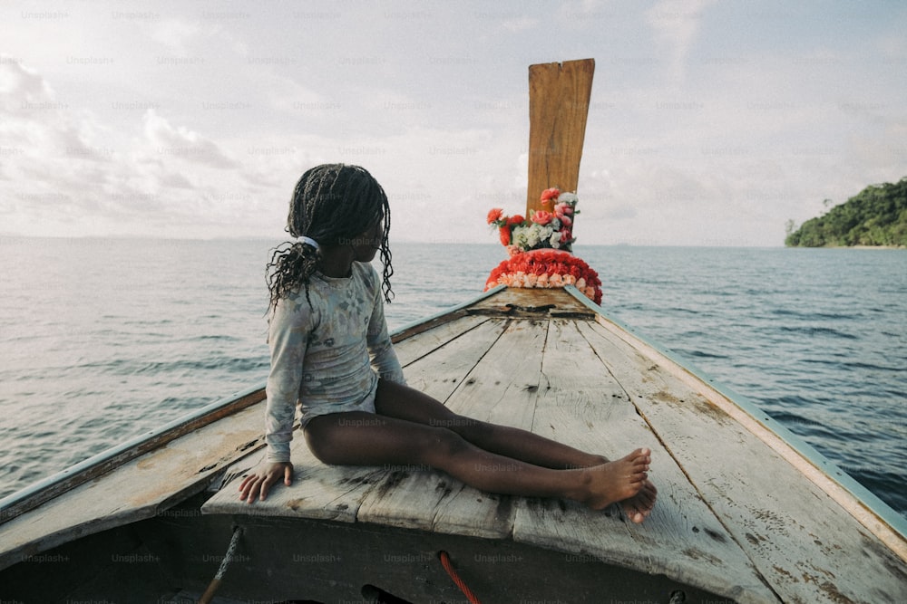 a girl sitting on a boat in the water