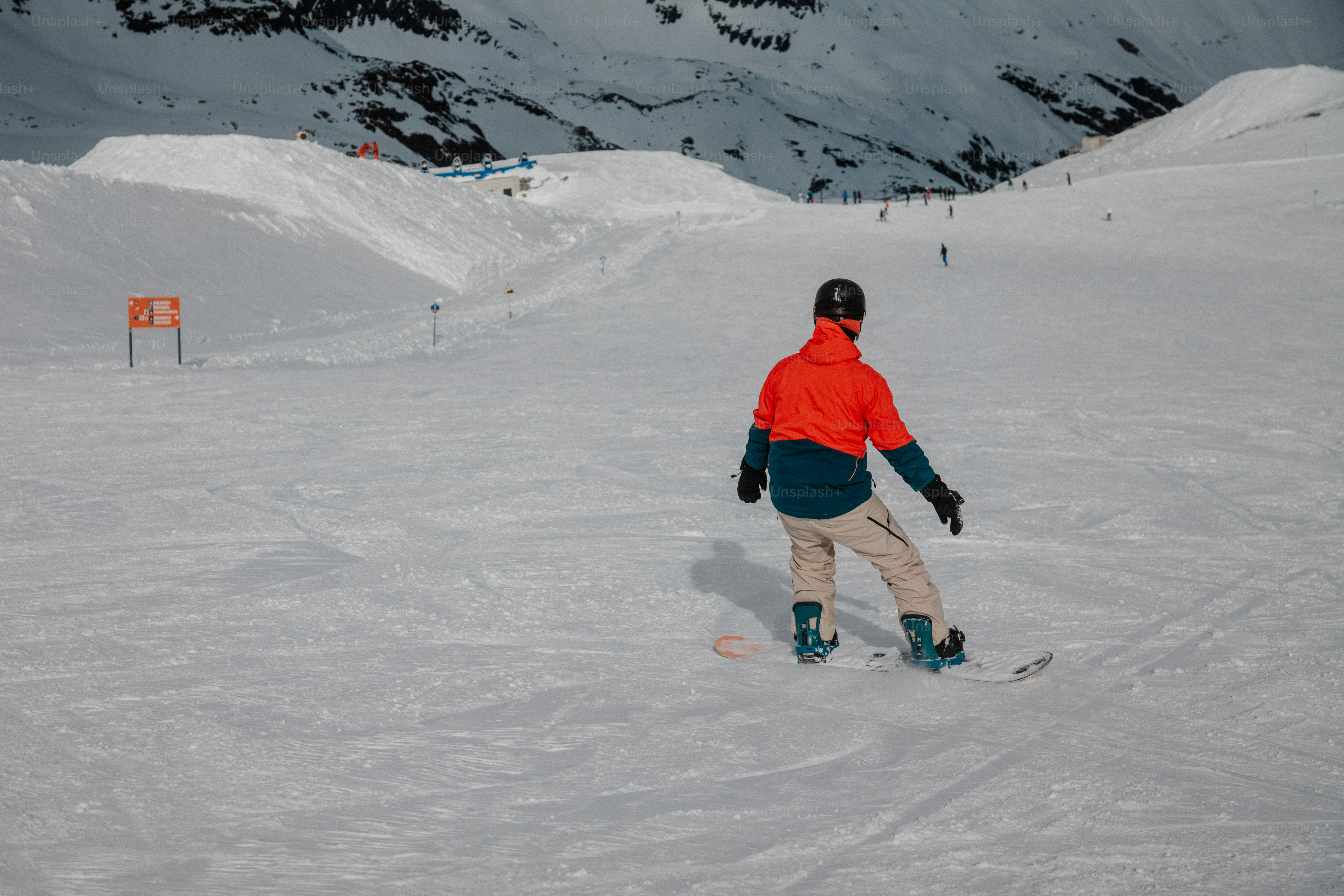 a man riding a snowboard down a snow covered slope