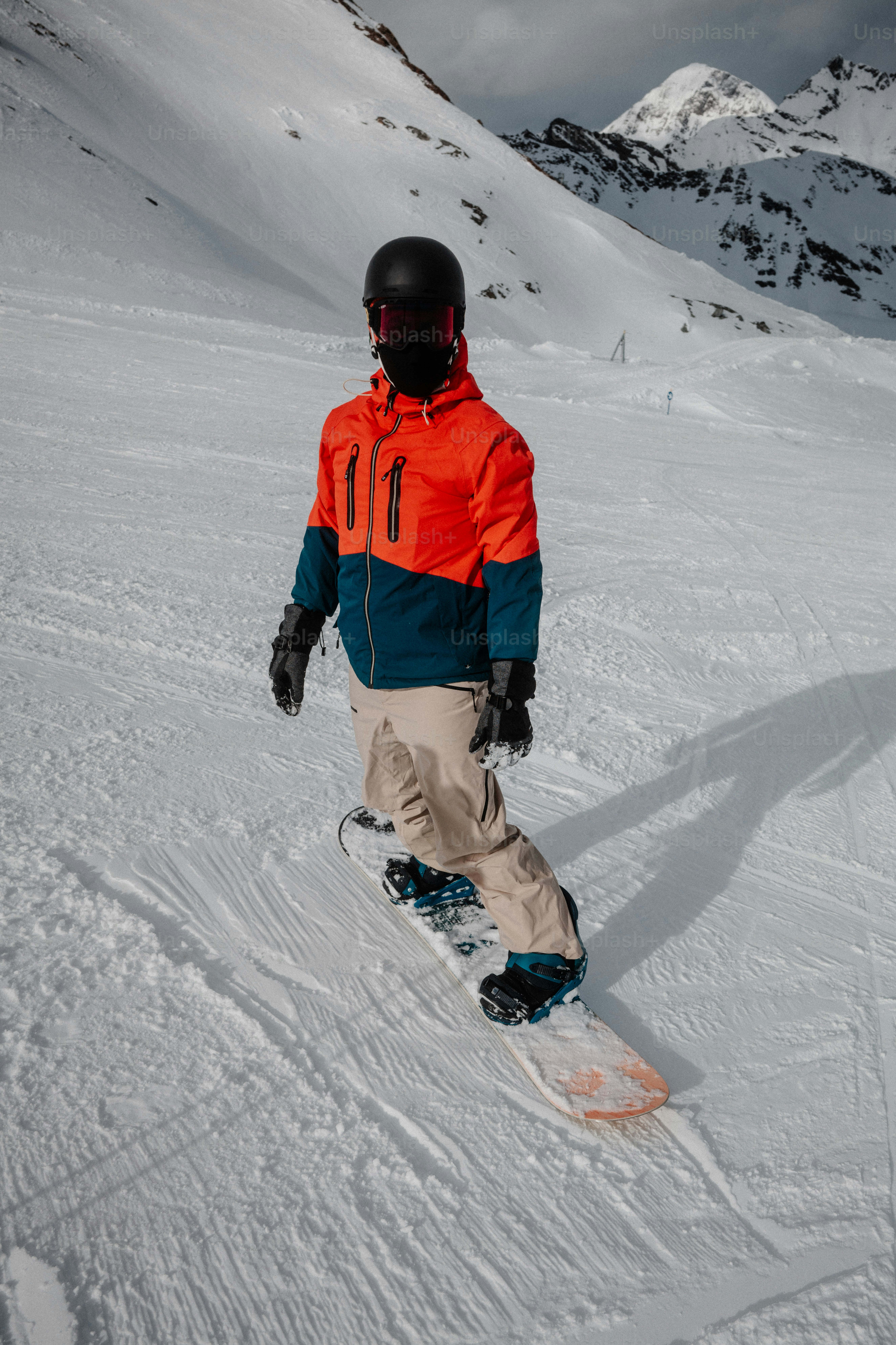 a man riding a snowboard down a snow covered slope