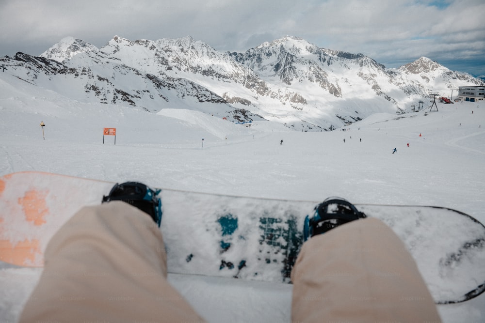 eine Person mit den Füßen auf einem Snowboard im Schnee