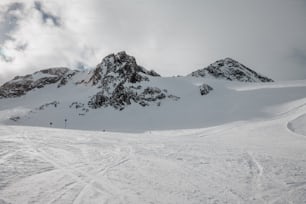 a group of people riding skis down a snow covered slope