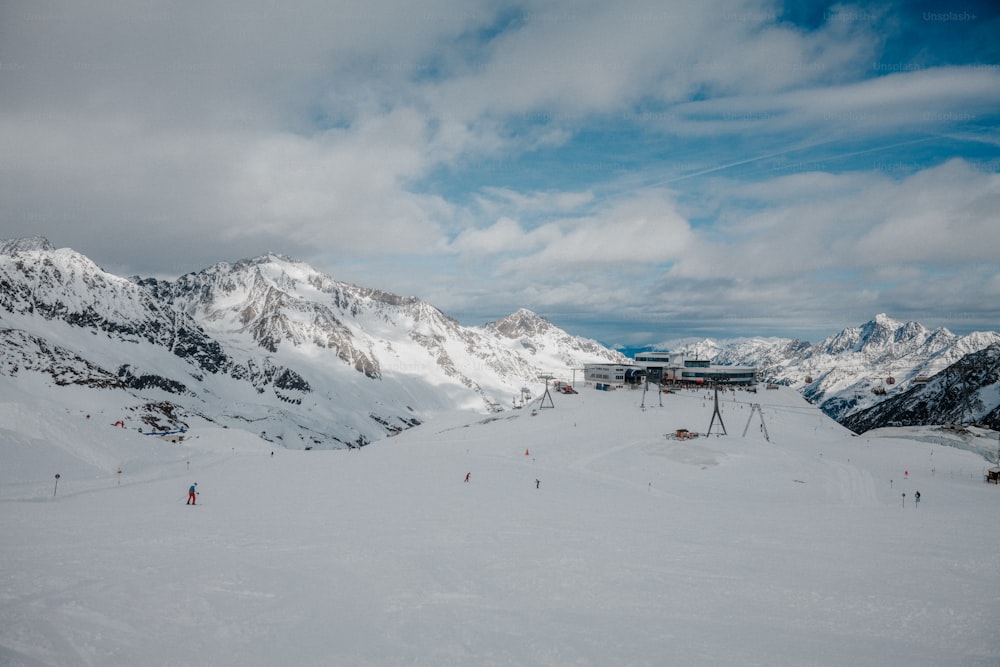 um grupo de pessoas andando de esqui no topo de uma encosta coberta de neve