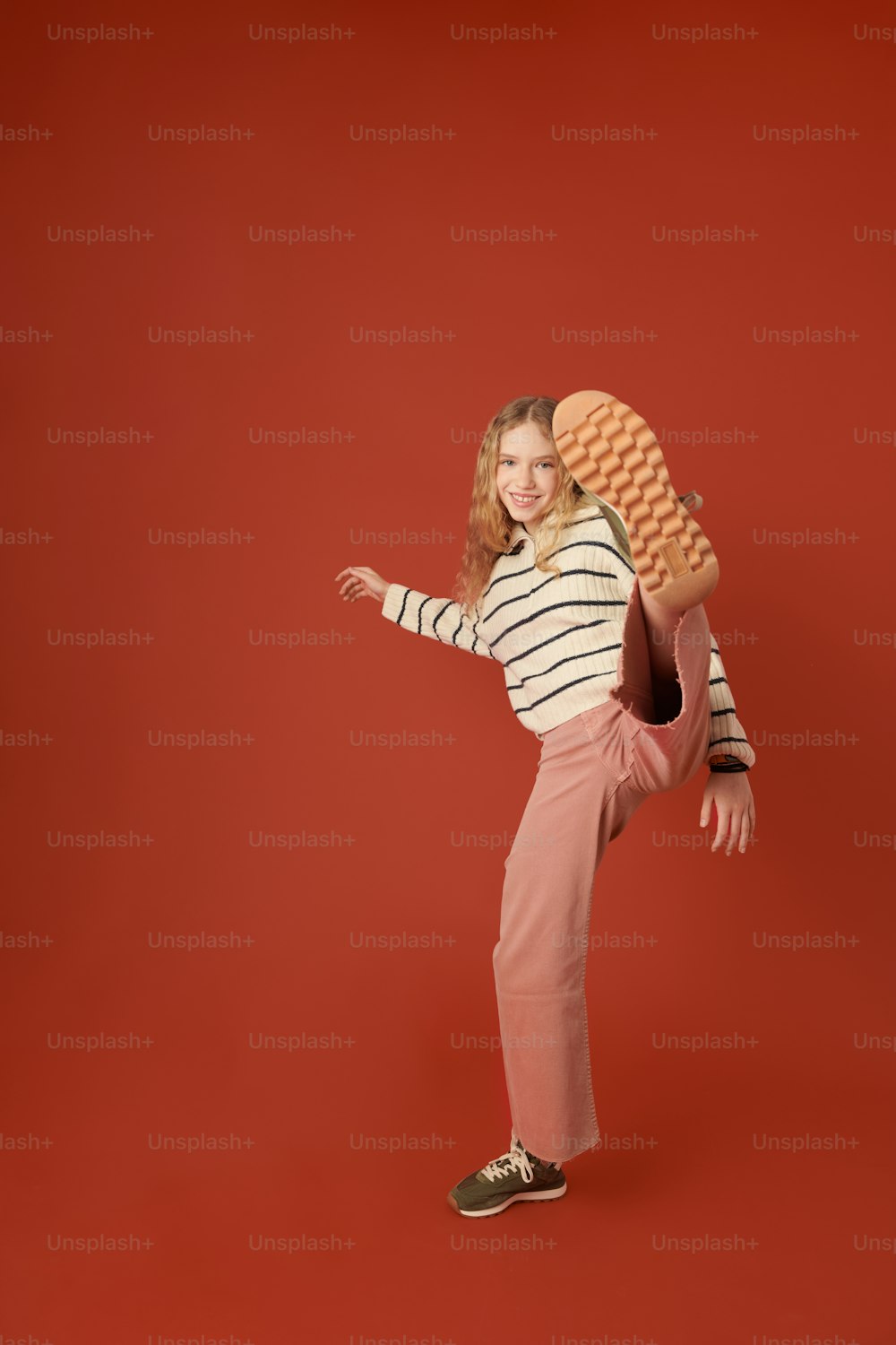 a young girl is posing with a skateboard on her back