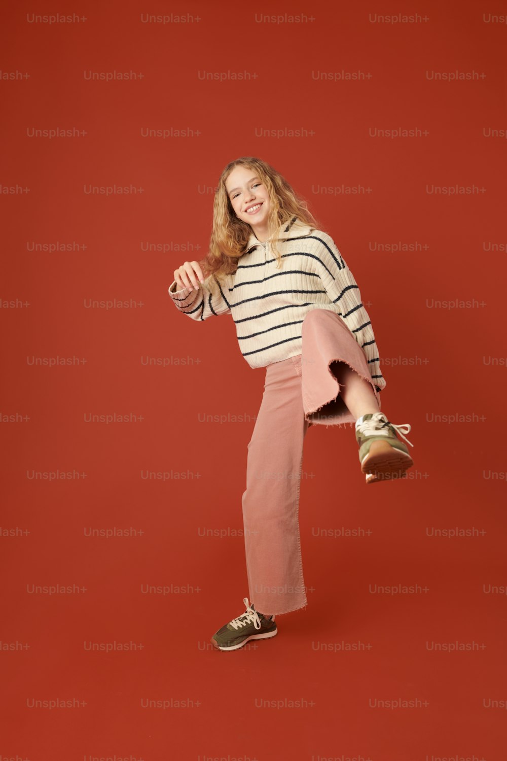 a woman in a striped shirt and pink pants