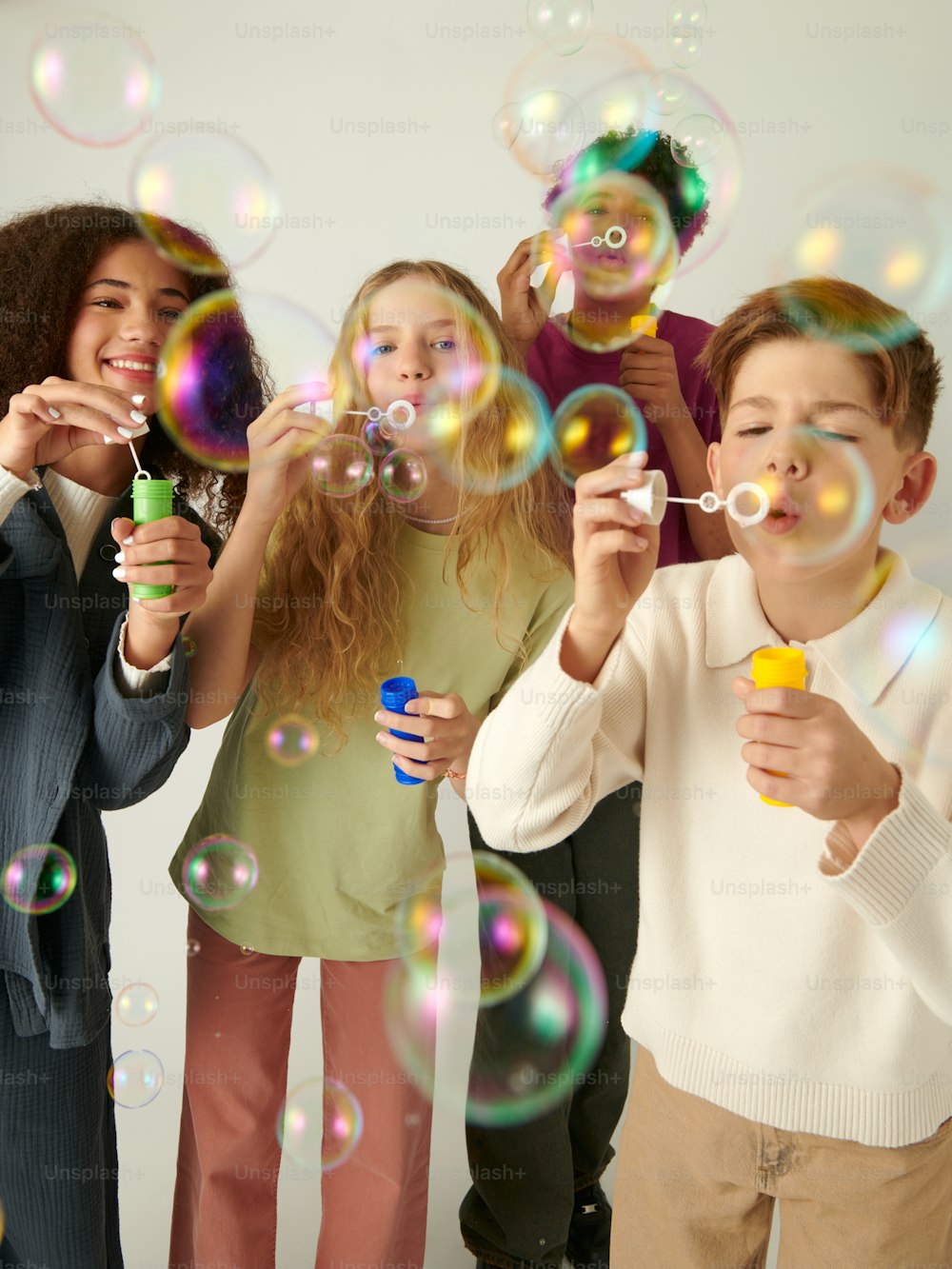 a group of children blowing bubbles in the air