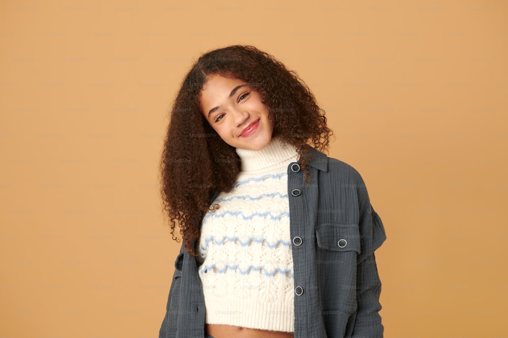 a woman with curly hair wearing a blue jacket