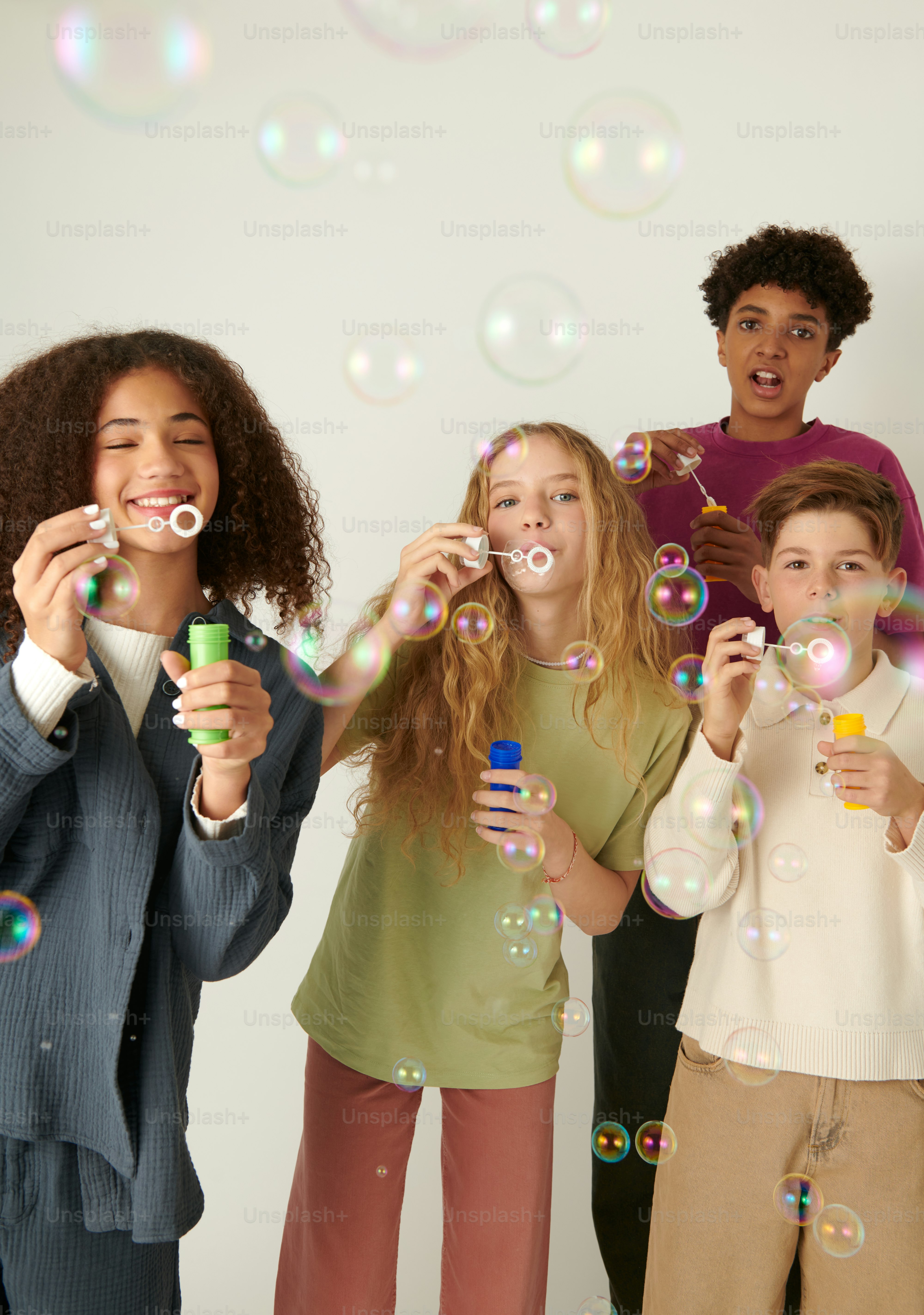 a group of children blowing bubbles in the air