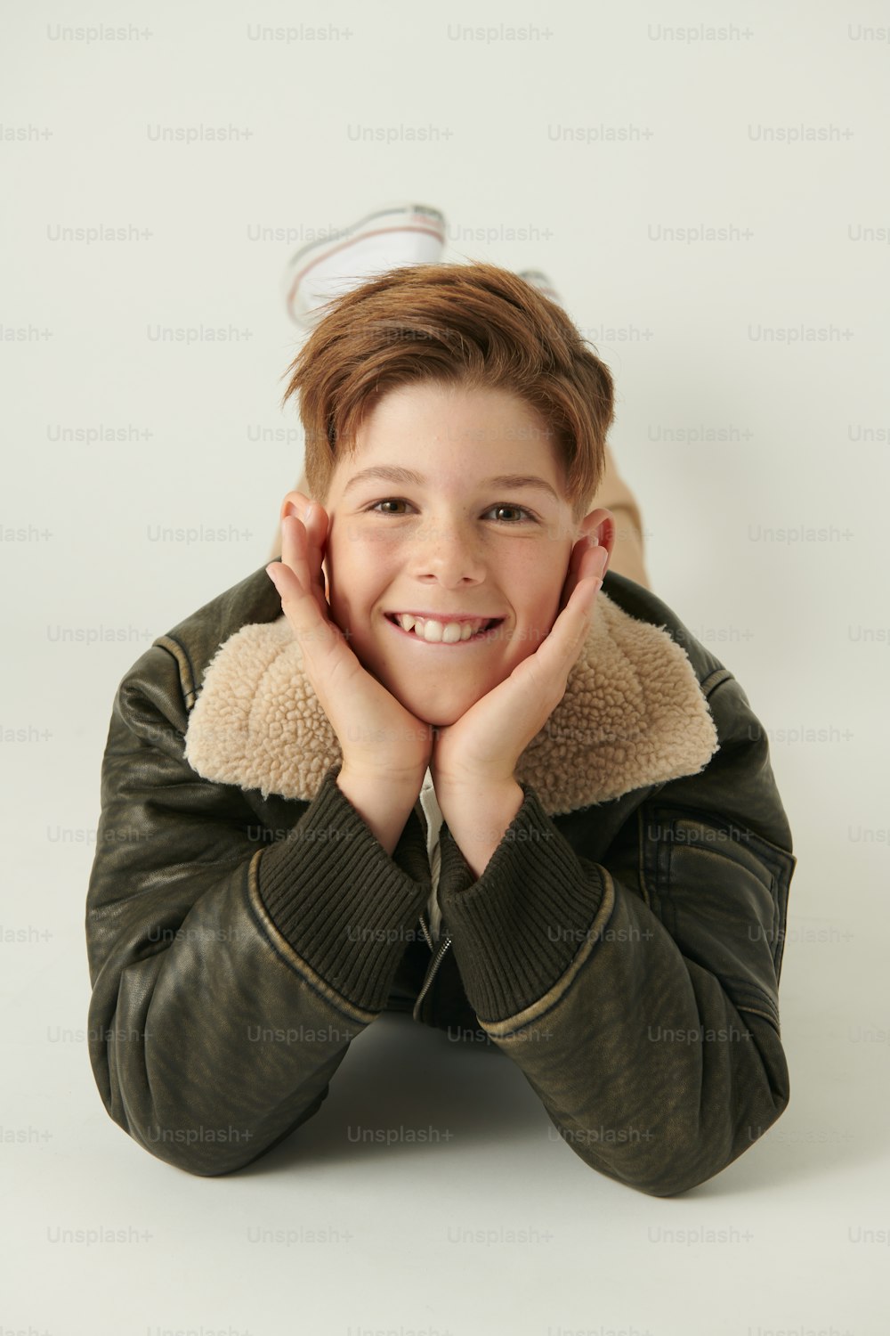 a young boy wearing a leather jacket and smiling