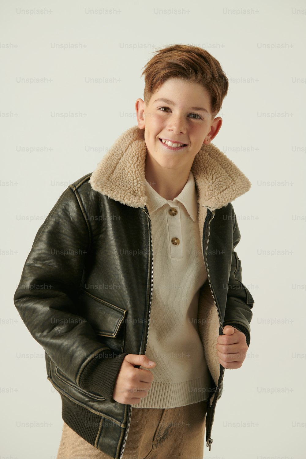 a young boy wearing a black leather jacket