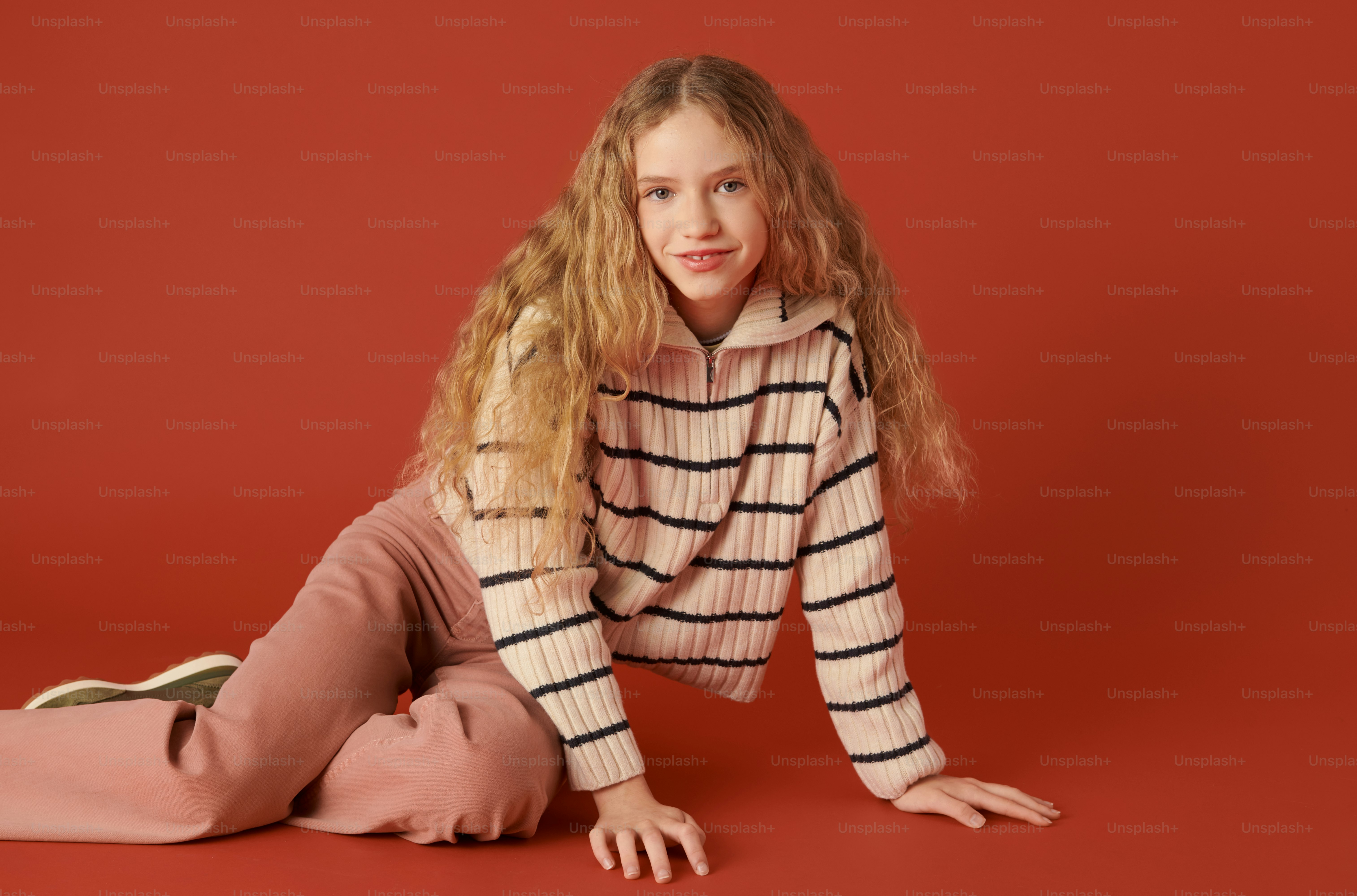 a woman laying on the ground wearing a sweater