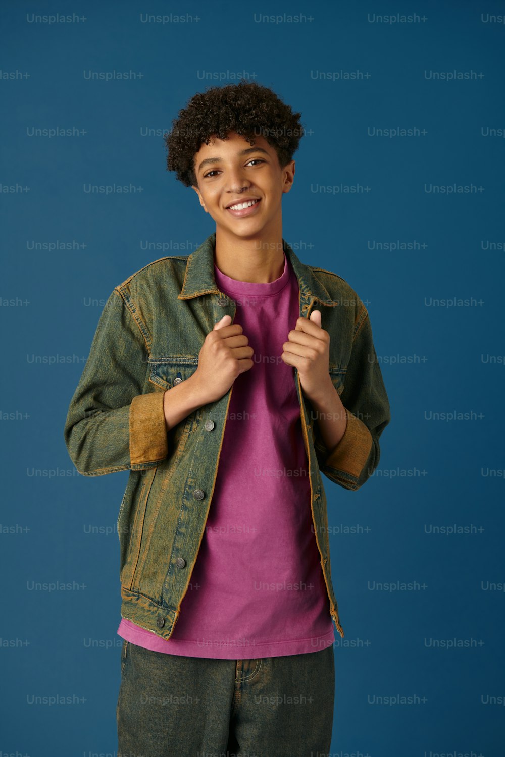 a young man in a pink shirt and green jacket