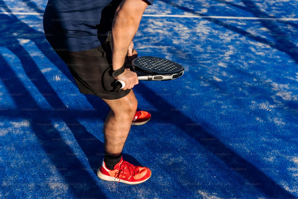 a man holding a tennis racquet on top of a tennis court