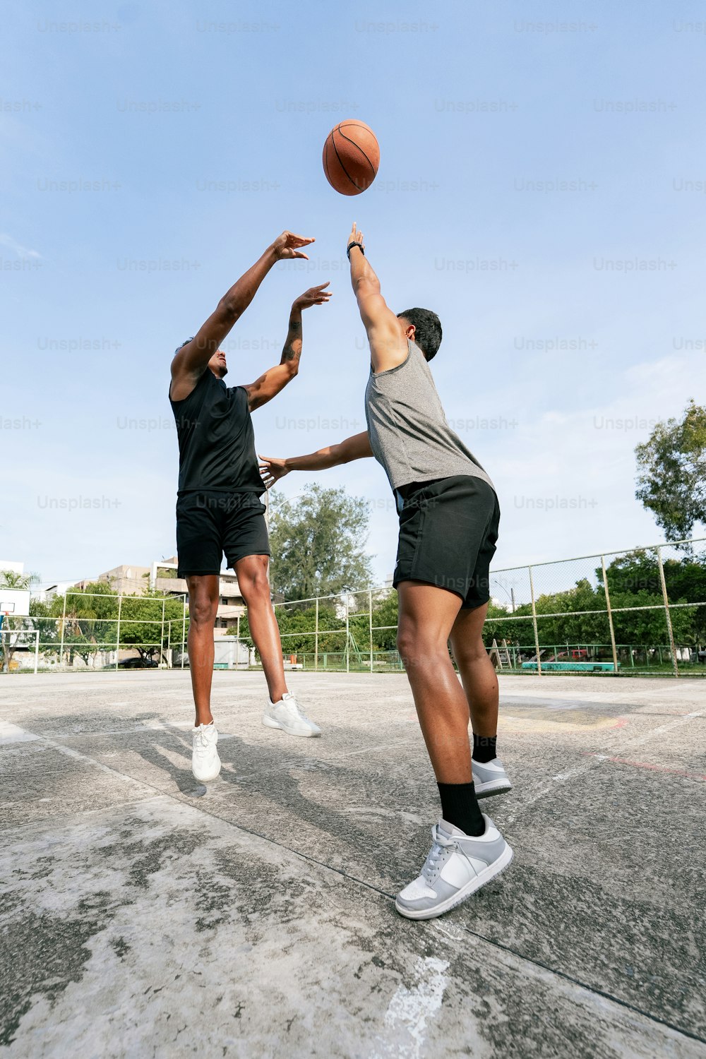 Dos hombres jugando al baloncesto en una cancha de baloncesto