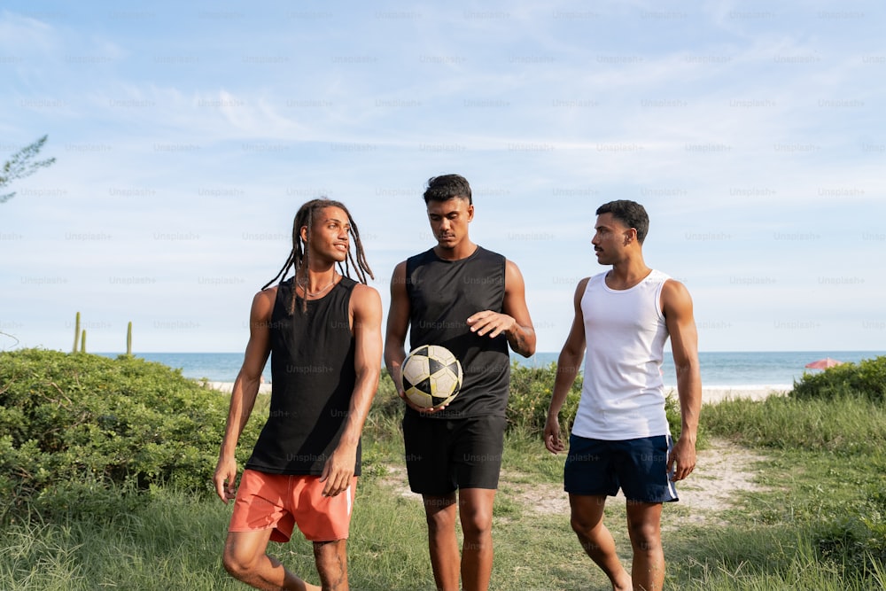 a group of young men standing next to each other holding a soccer ball