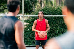 ein Mann in einem roten Hemd hält einen Basketball in der Hand