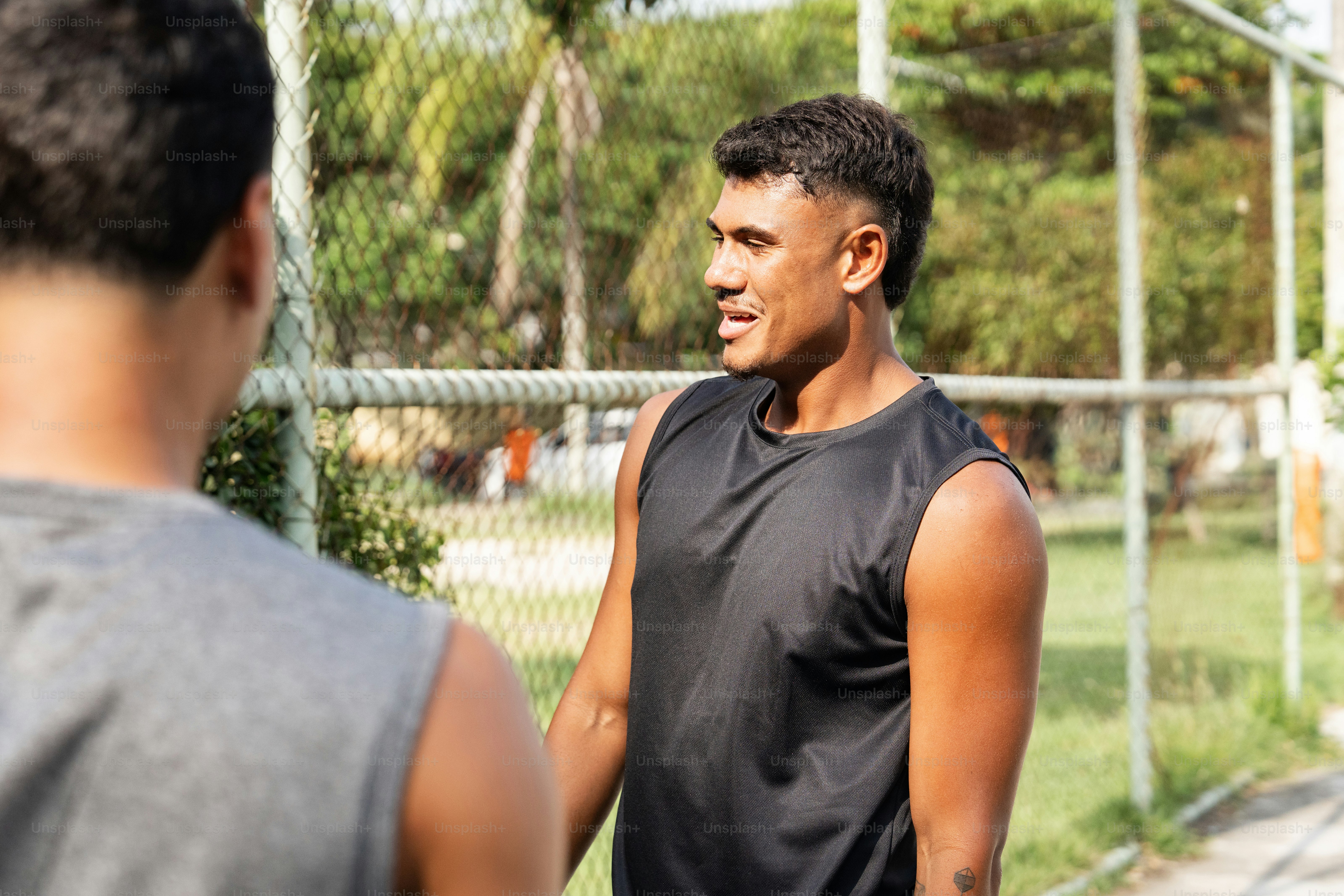 a man standing next to another man holding a tennis racquet
