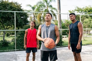un gruppo di giovani in piedi uno accanto all'altro con in mano un pallone da basket