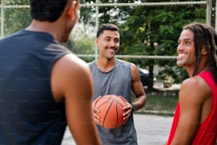 un gruppo di uomini in piedi l'uno intorno all'altro con in mano un pallone da basket