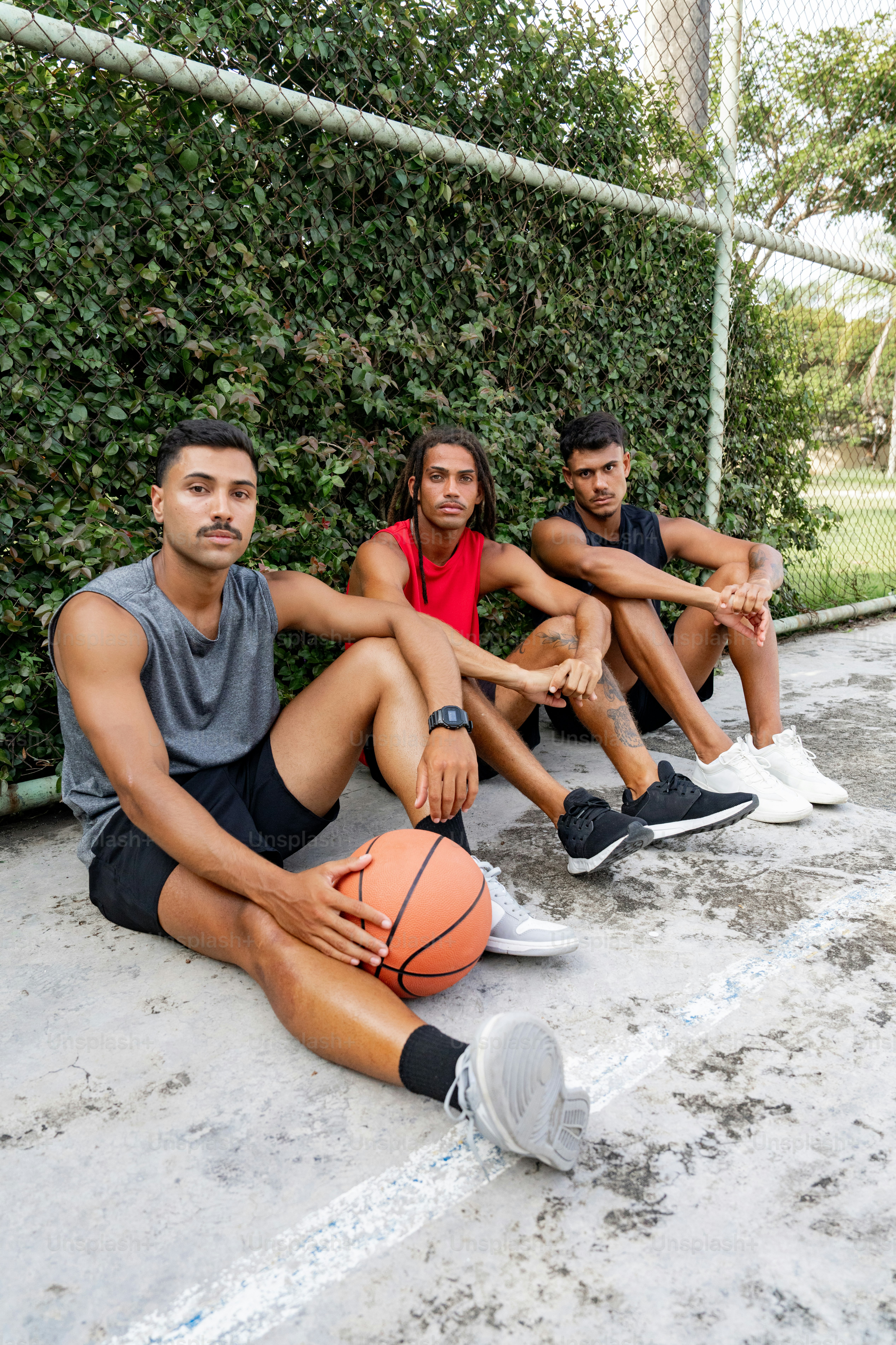 a group of young men sitting next to each other on a basketball court