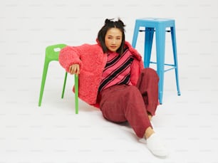 a woman sitting on the ground next to three stools