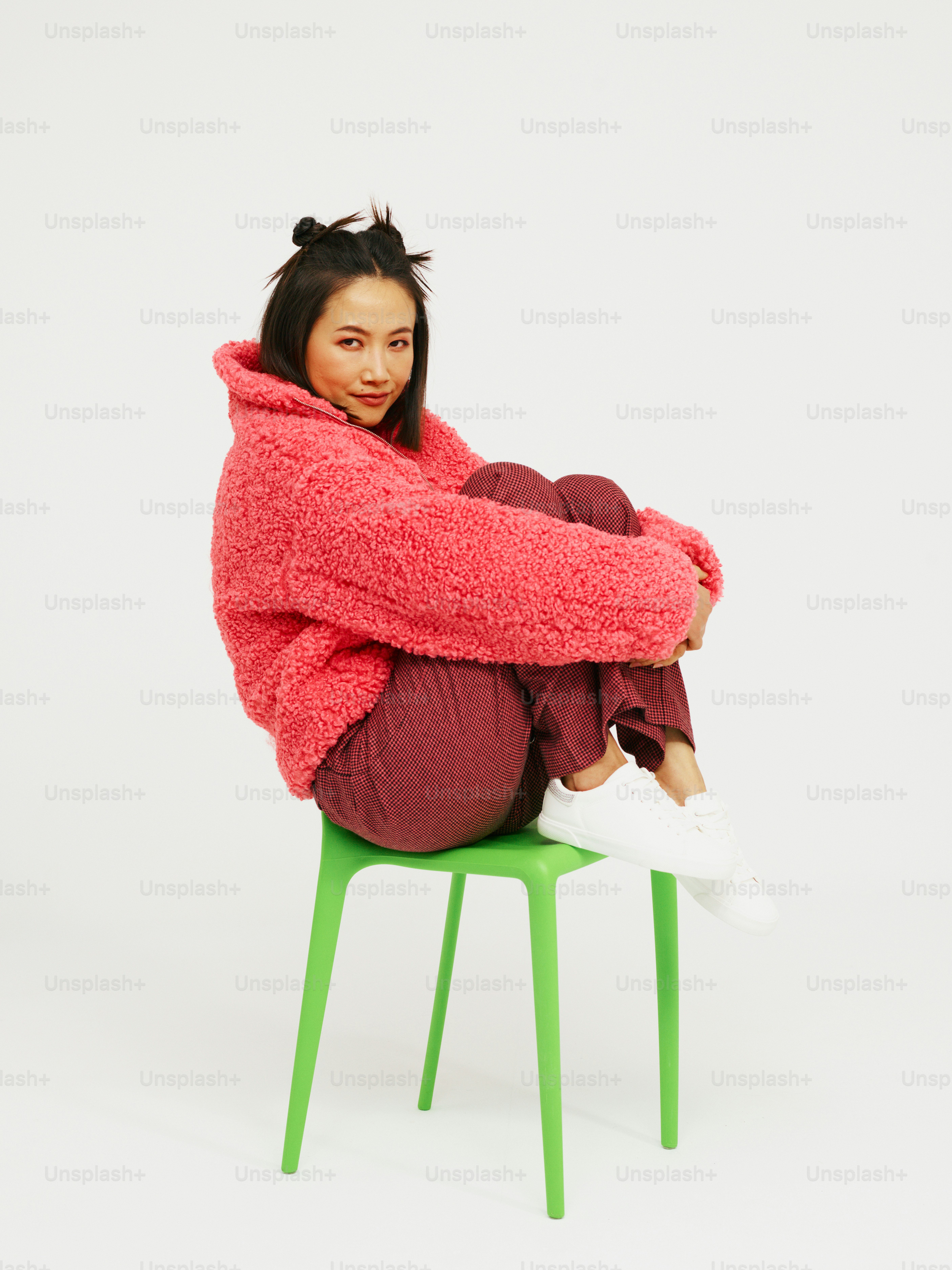 une femme assise sur une chaise verte