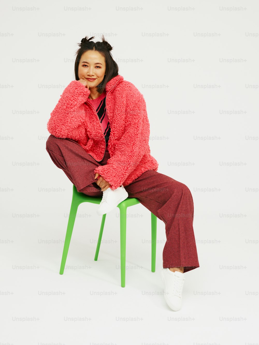 a woman is sitting on a green chair