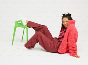 a woman sitting on the ground with a chair behind her