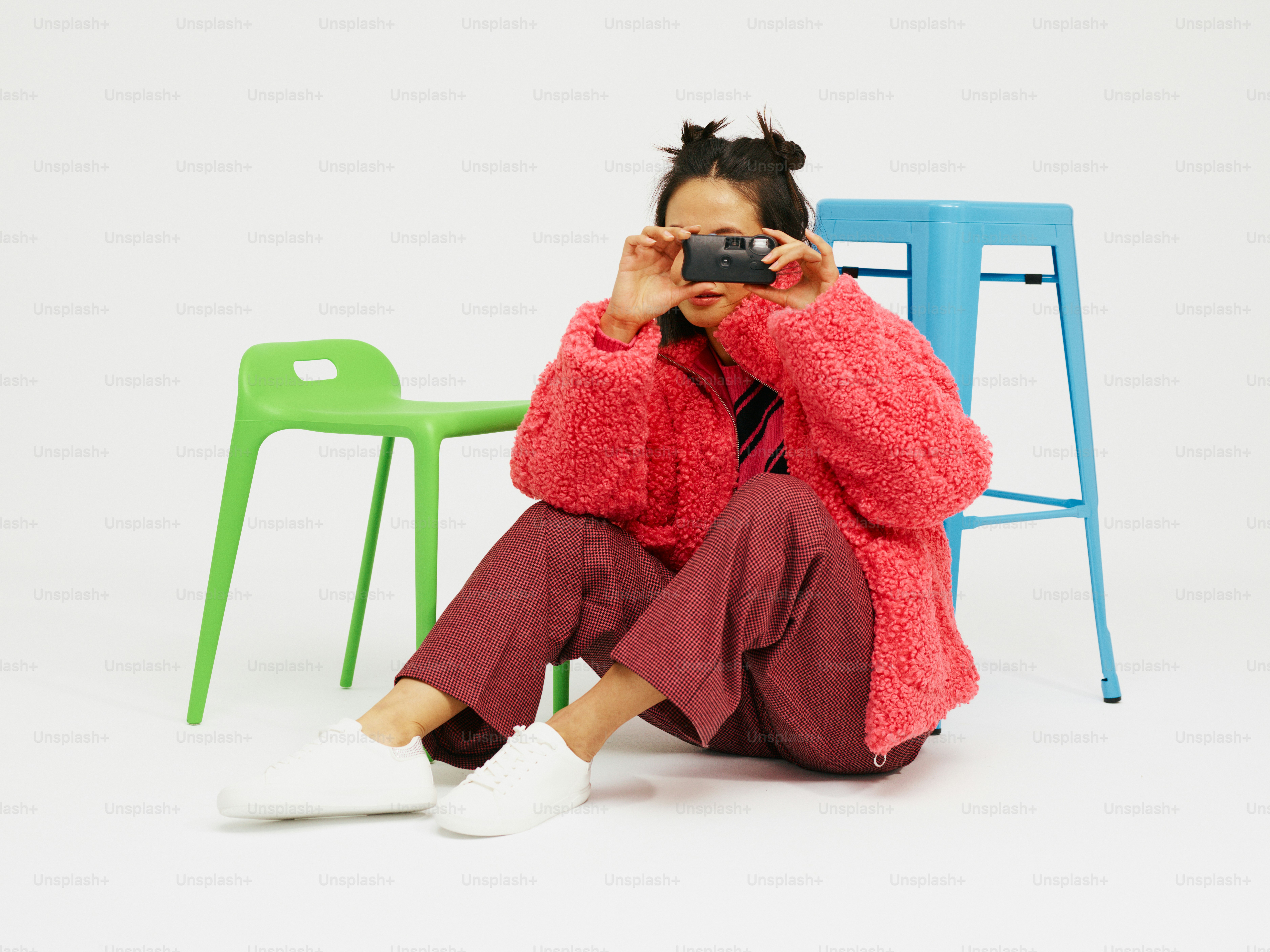 a woman sitting on a chair taking a picture of herself