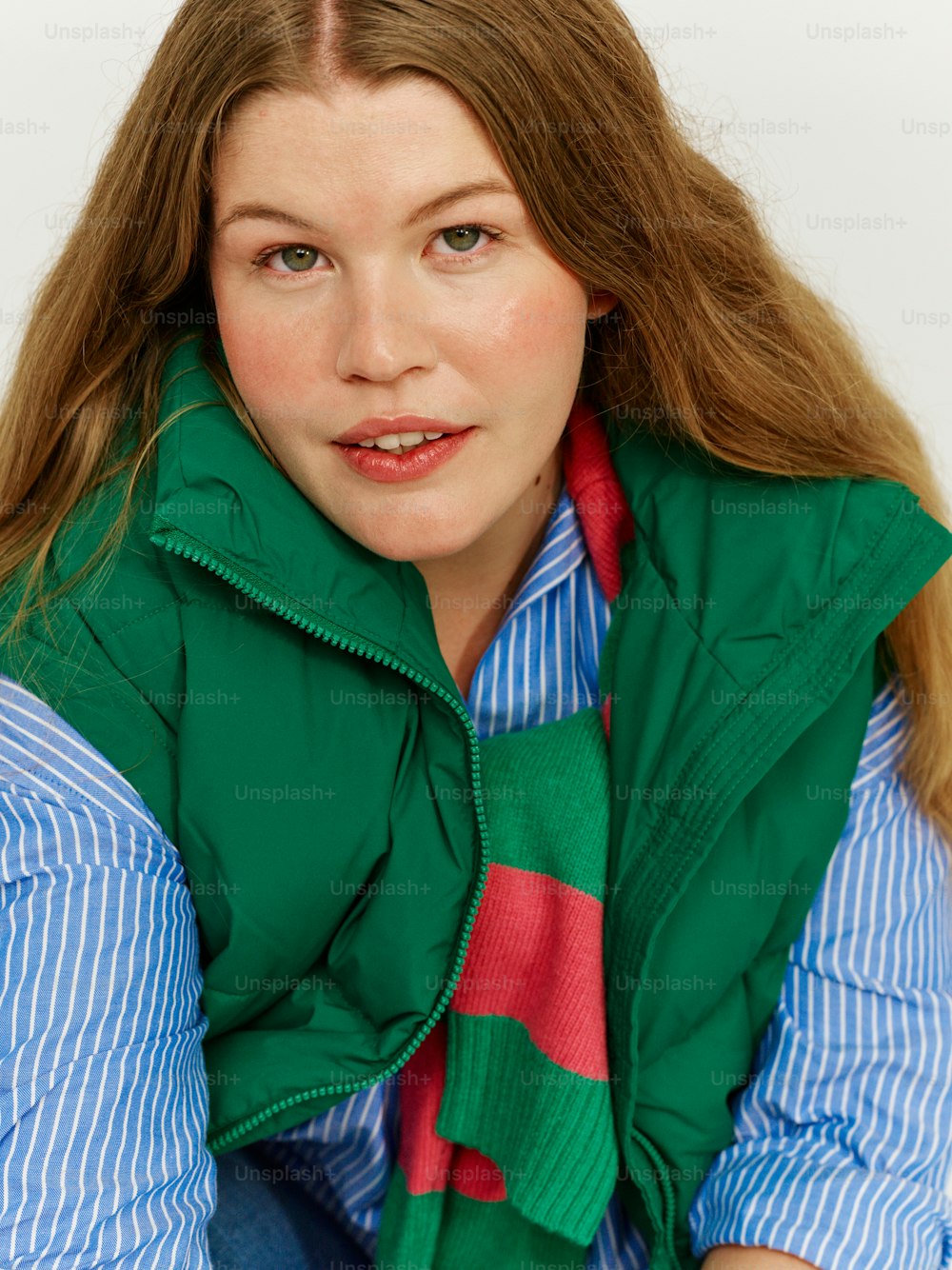 uma mulher vestindo um colete verde e uma gravata vermelha e azul