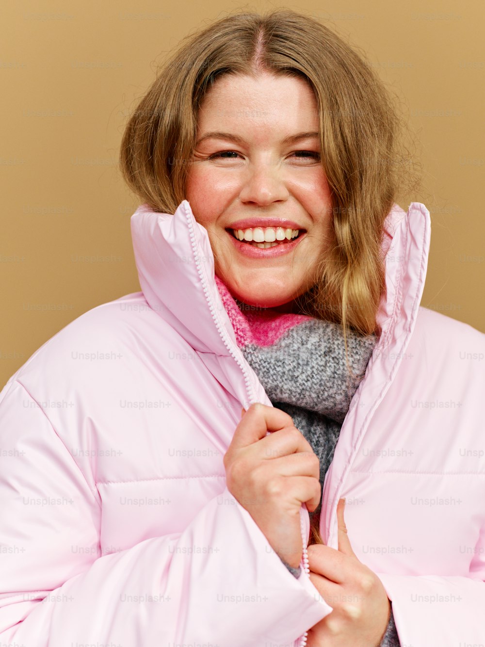 a woman wearing a pink coat and a pink scarf