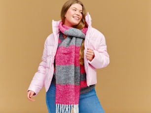 a woman wearing a pink jacket and a pink and grey scarf