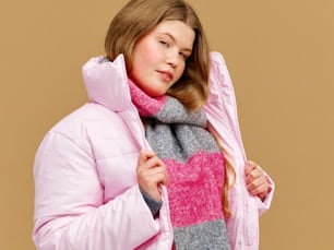a woman in a pink jacket and a pink and grey scarf