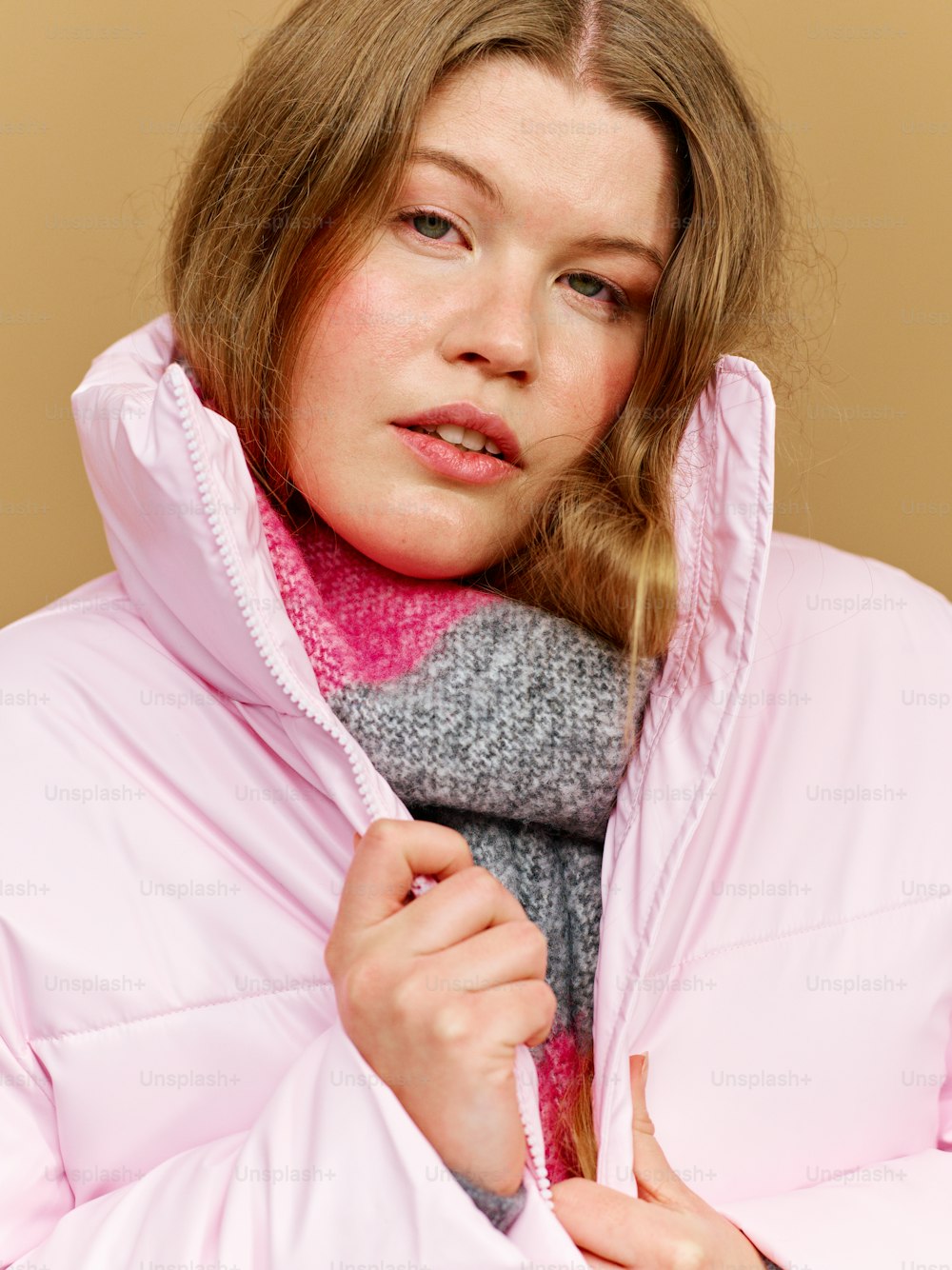 a woman wearing a pink coat and a pink scarf