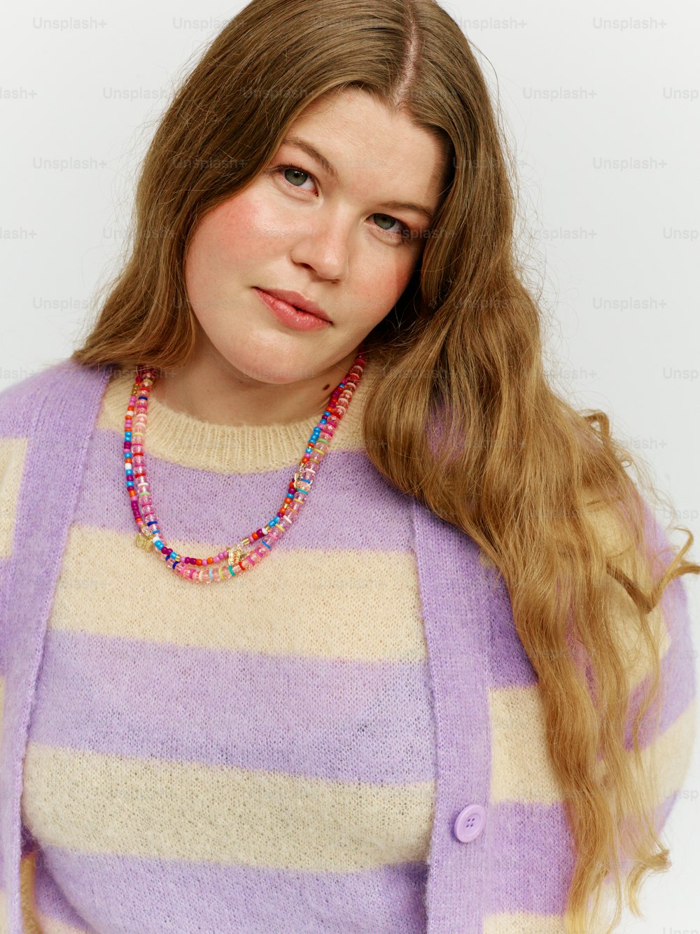 a woman with long hair wearing a purple and white sweater