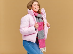 uma mulher em uma jaqueta rosa e lenço