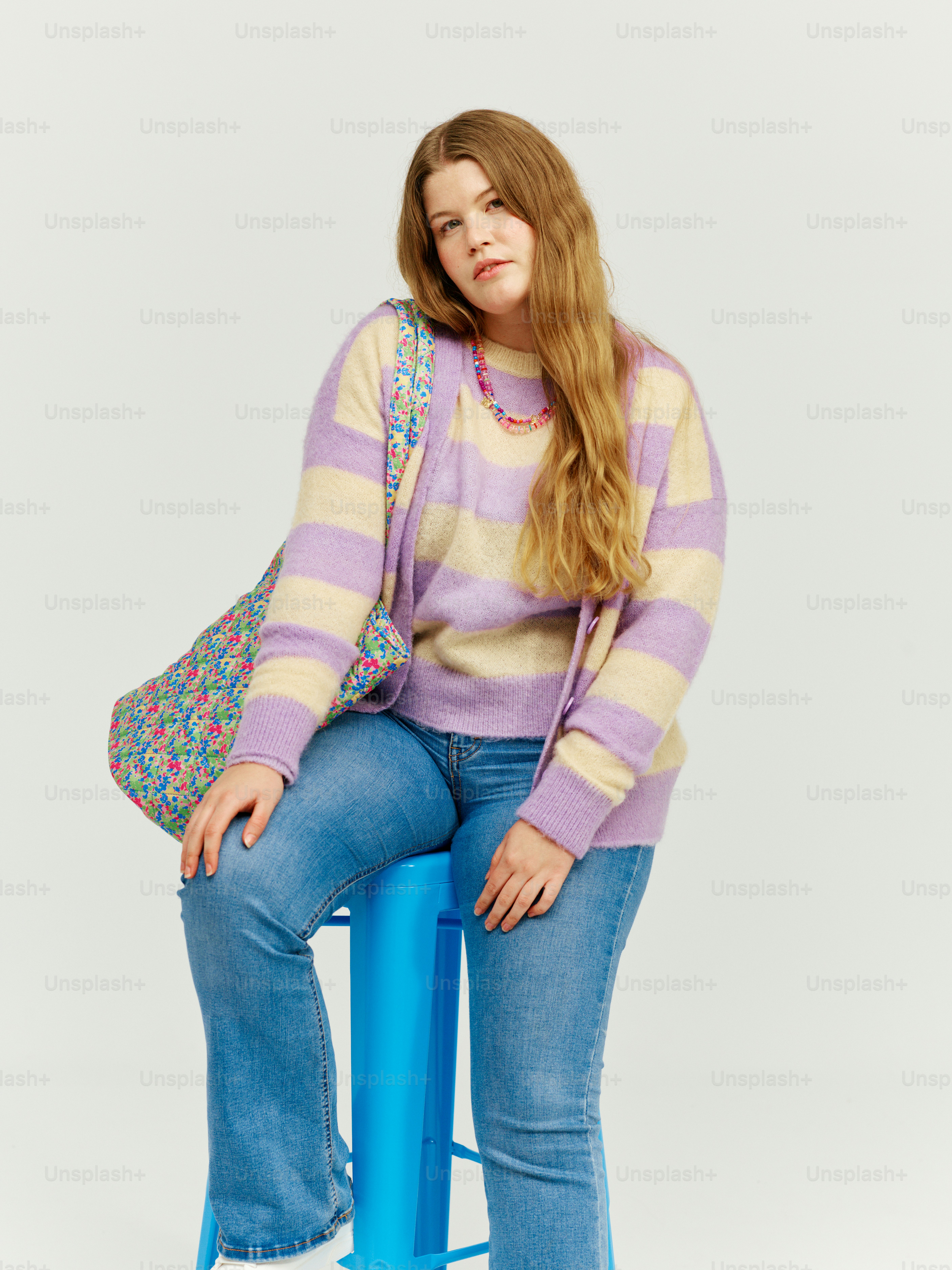 a woman sitting on top of a blue stool