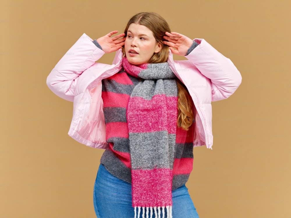 a woman wearing a pink and grey striped scarf