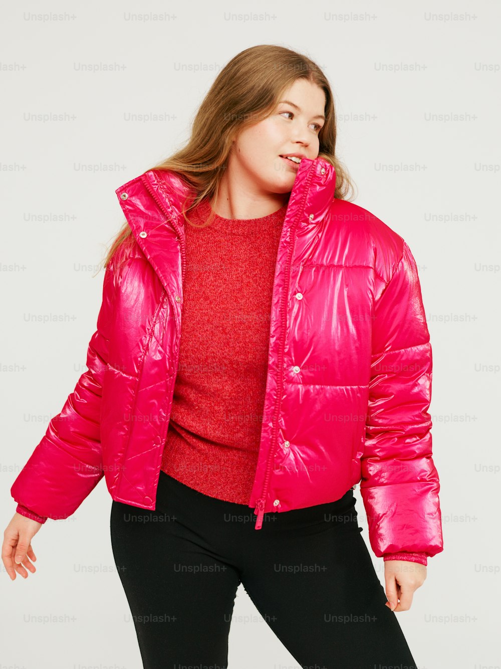 a woman wearing a bright pink jacket and black pants