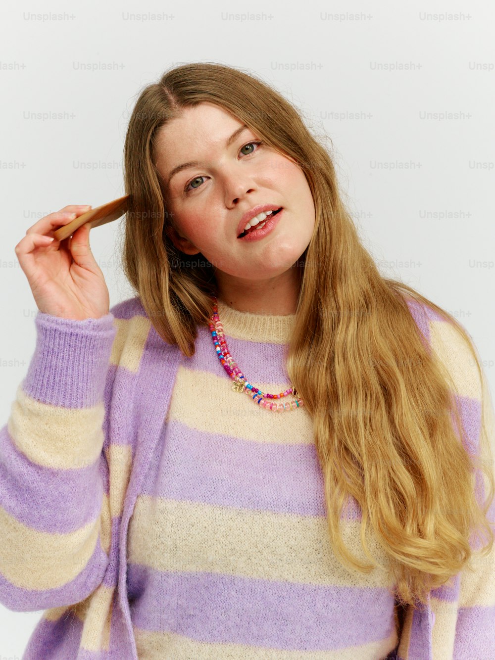 a woman in a striped sweater is holding a cigarette