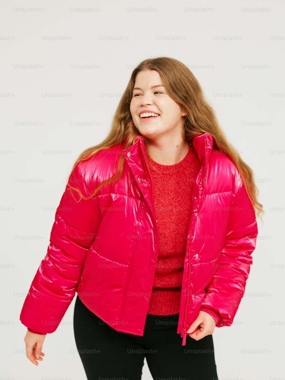 a woman in a bright pink jacket and black pants