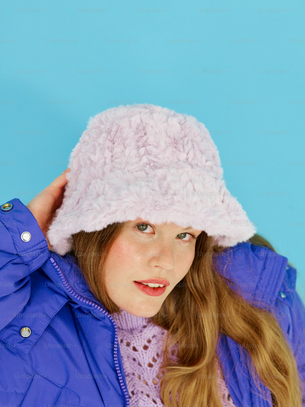una joven con un sombrero rosa y una chaqueta morada