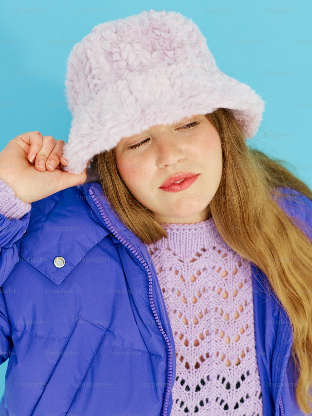 a young girl wearing a purple jacket and a pink hat