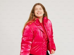 a woman wearing a bright pink jacket and black pants